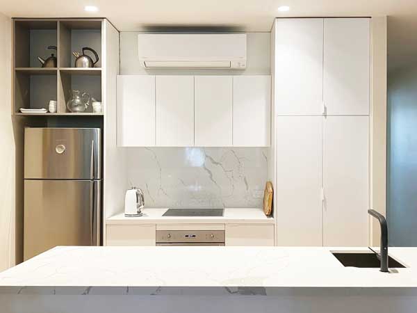 Small Kitchen Renovation Featuring White Cupboards for Added Utility