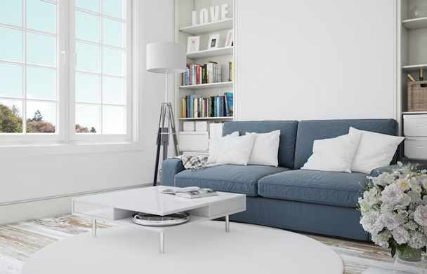 Minimalist living room with a blue sofa, white coffee table, large window, and bookshelf.