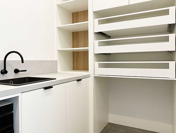 Modern white kitchen with black faucet, open drawers, and wood shelving. Minimalist design. Modern white kitchen with black faucet, open drawers, and wood shelving. Minimalist design.