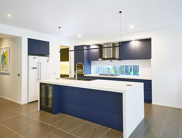 Modern kitchen with a large island, navy blue cabinets, white countertops, and pendant lighting. Modern kitchen with a large island, navy blue cabinets, white countertops, and pendant lighting.