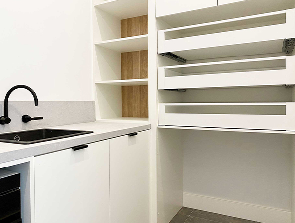 Minimalist kitchen with open shelves, a black faucet, and a countertop. White cabinetry and light wood accents. Minimalist kitchen with open shelves, a black faucet, and a countertop. White cabinetry and light wood accents.