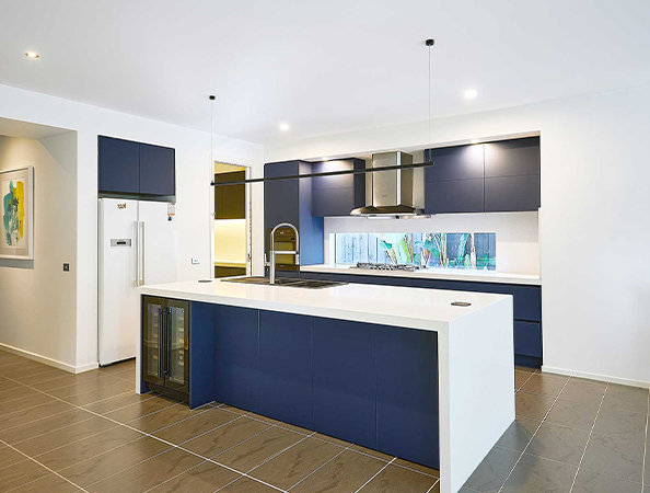 Modern kitchen with navy cabinets, white countertops, a central island, stainless steel appliances, and pendant lights. Modern kitchen with navy cabinets, white countertops, a central island, stainless steel appliances, and pendant lights.