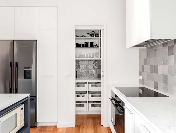 Modern kitchen with open pantry, stainless steel appliances, and white cabinets on wooden flooring. Modern kitchen with open pantry, stainless steel appliances, and white cabinets on wooden flooring.