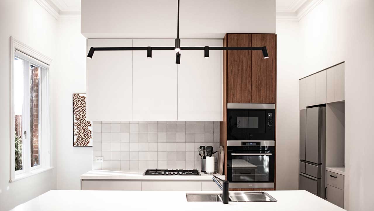 Modern kitchen with white cabinets, a black light fixture, and stainless steel appliances. Modern kitchen with white cabinets, a black light fixture, and stainless steel appliances.