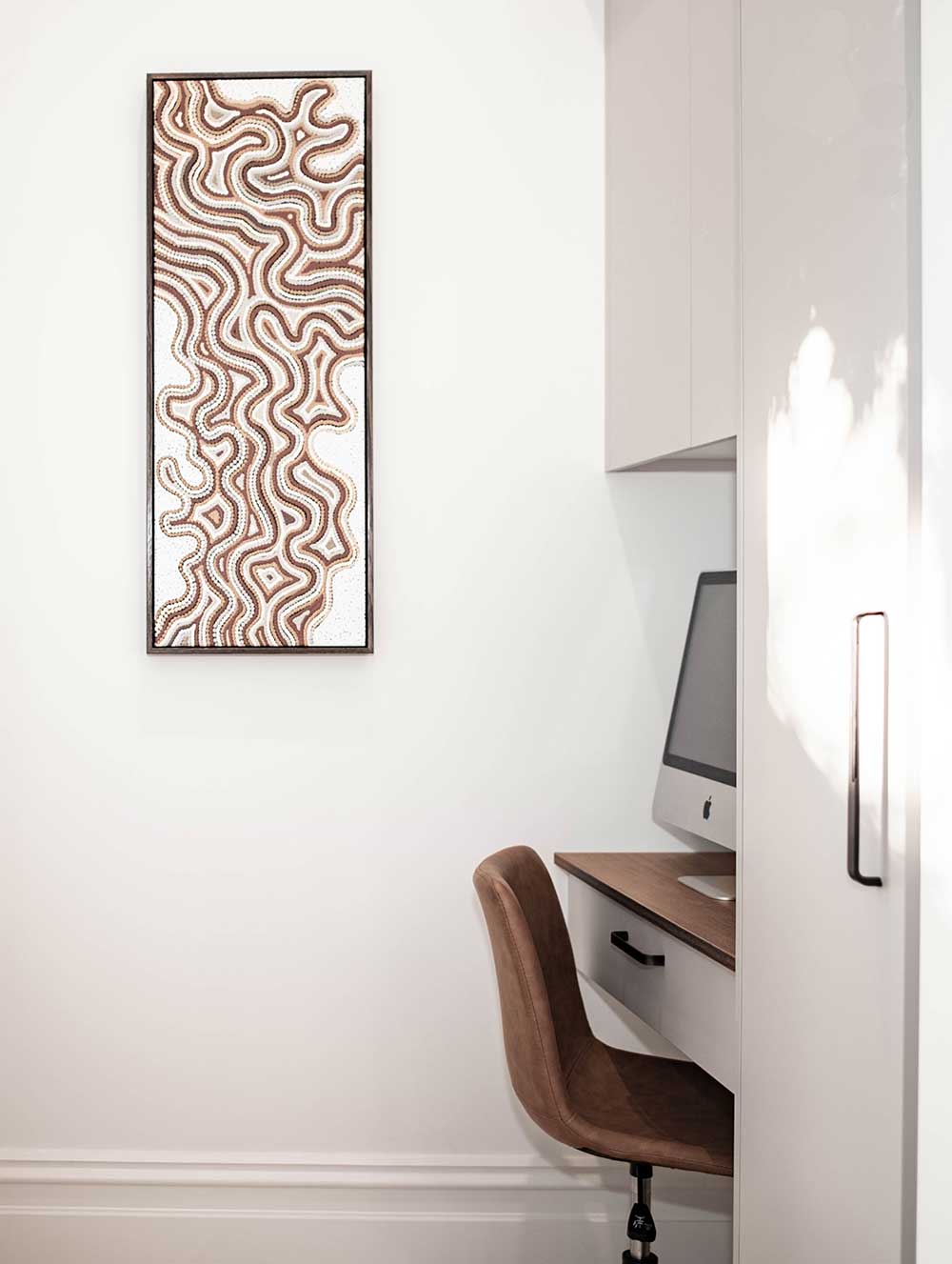 Minimalist office space with a computer desk and abstract art piece on a white wall. Minimalist office space with a computer desk and abstract art piece on a white wall.