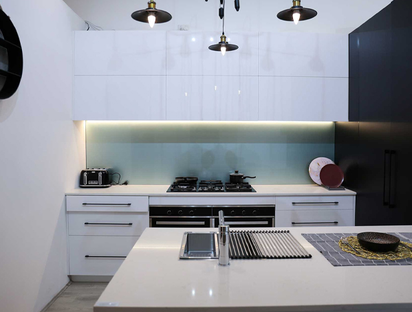 Modern kitchen with white cabinets, black appliances, and an island countertop with decor. Modern kitchen with white cabinets, black appliances, and an island countertop with decor.