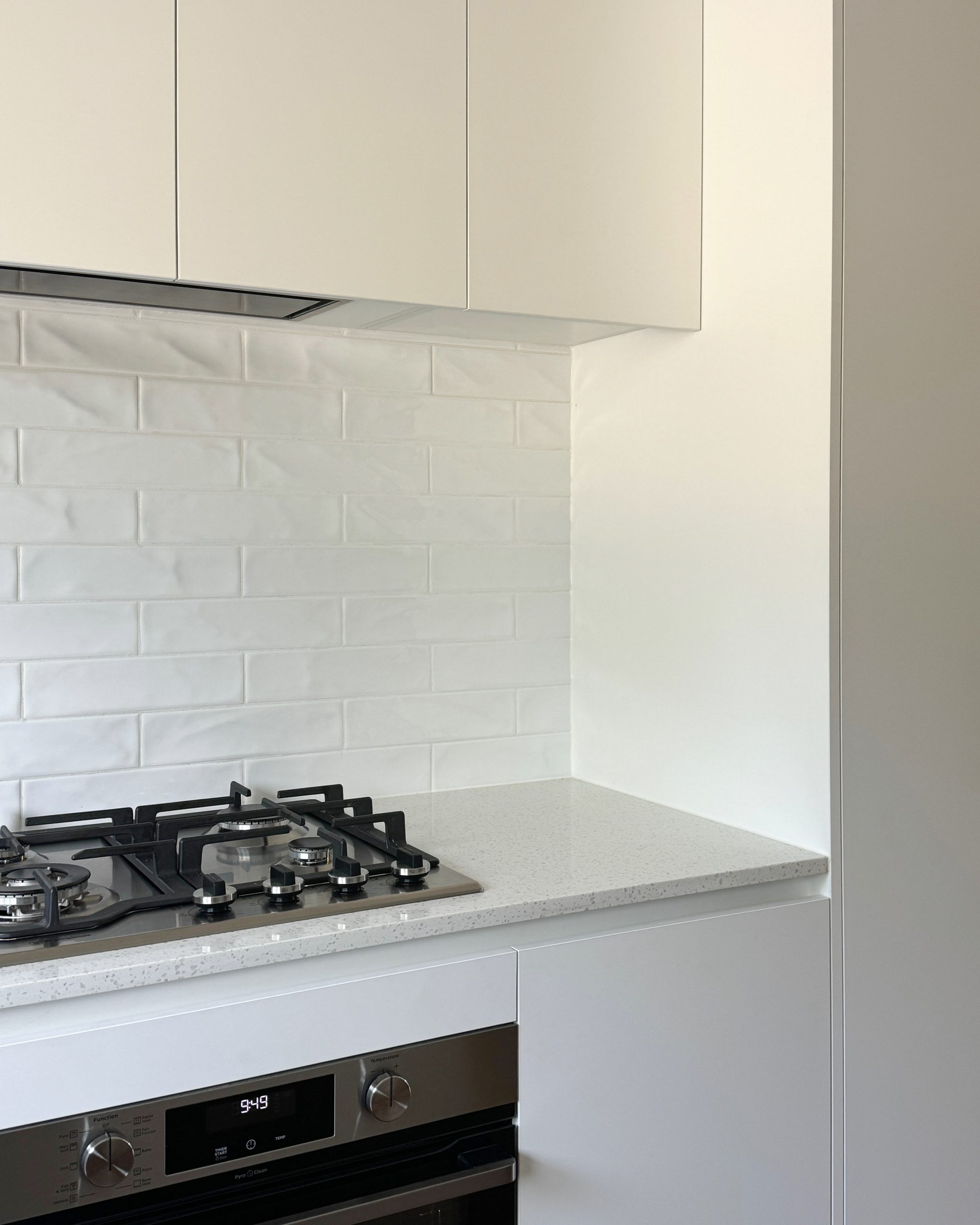 Modern kitchen with a gas stove, white cabinets, and a white tile backsplash. Modern kitchen with a gas stove, white cabinets, and a white tile backsplash.