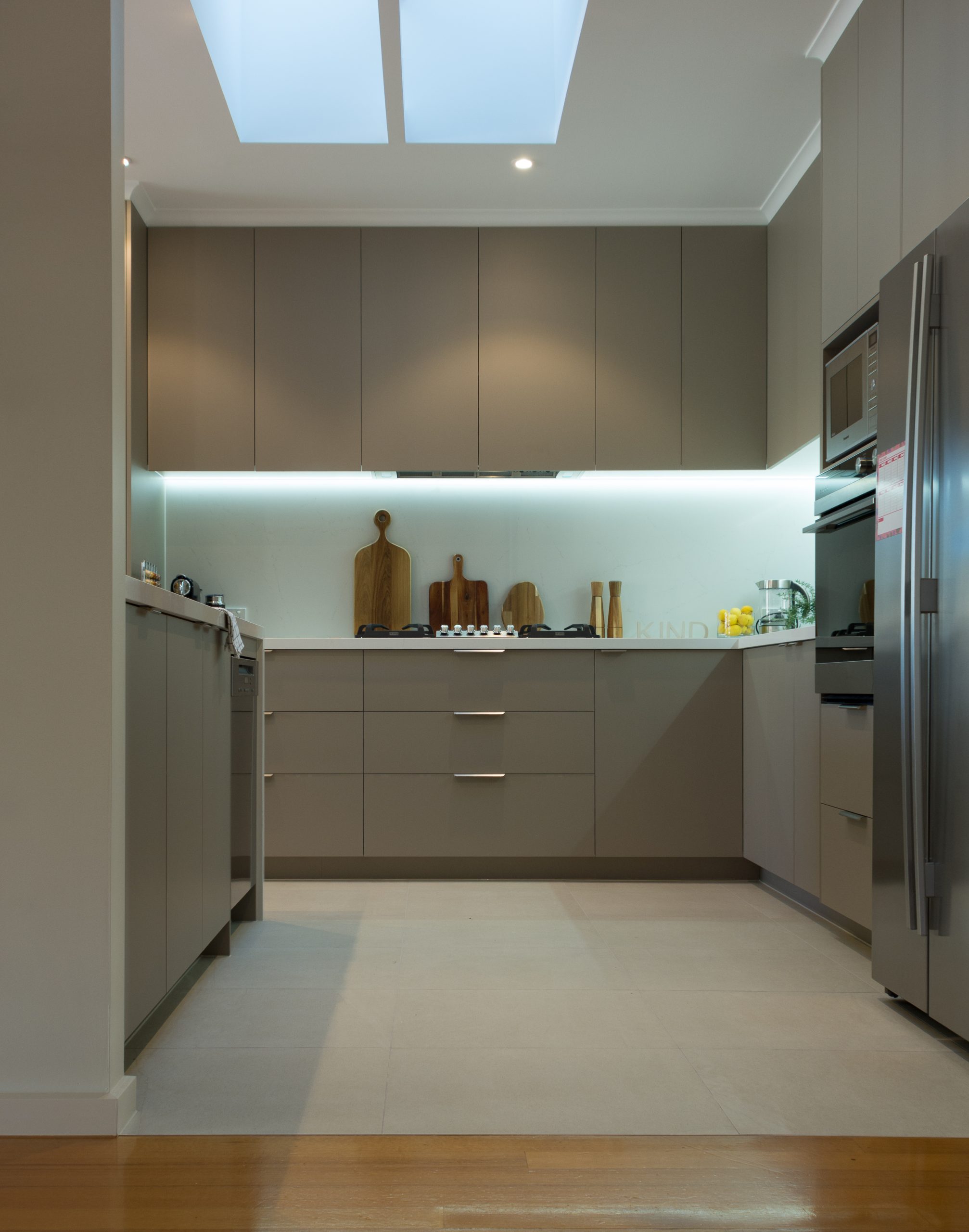 Modern kitchen with gray cabinets, stainless steel appliances, wooden cutting boards, and a skylight for natural light. Modern kitchen with gray cabinets, stainless steel appliances, wooden cutting boards, and a skylight for natural light.